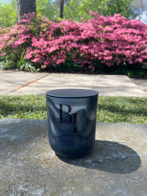 Onyx Embers natural soy candle displayed in an outdoor lifestyle setting