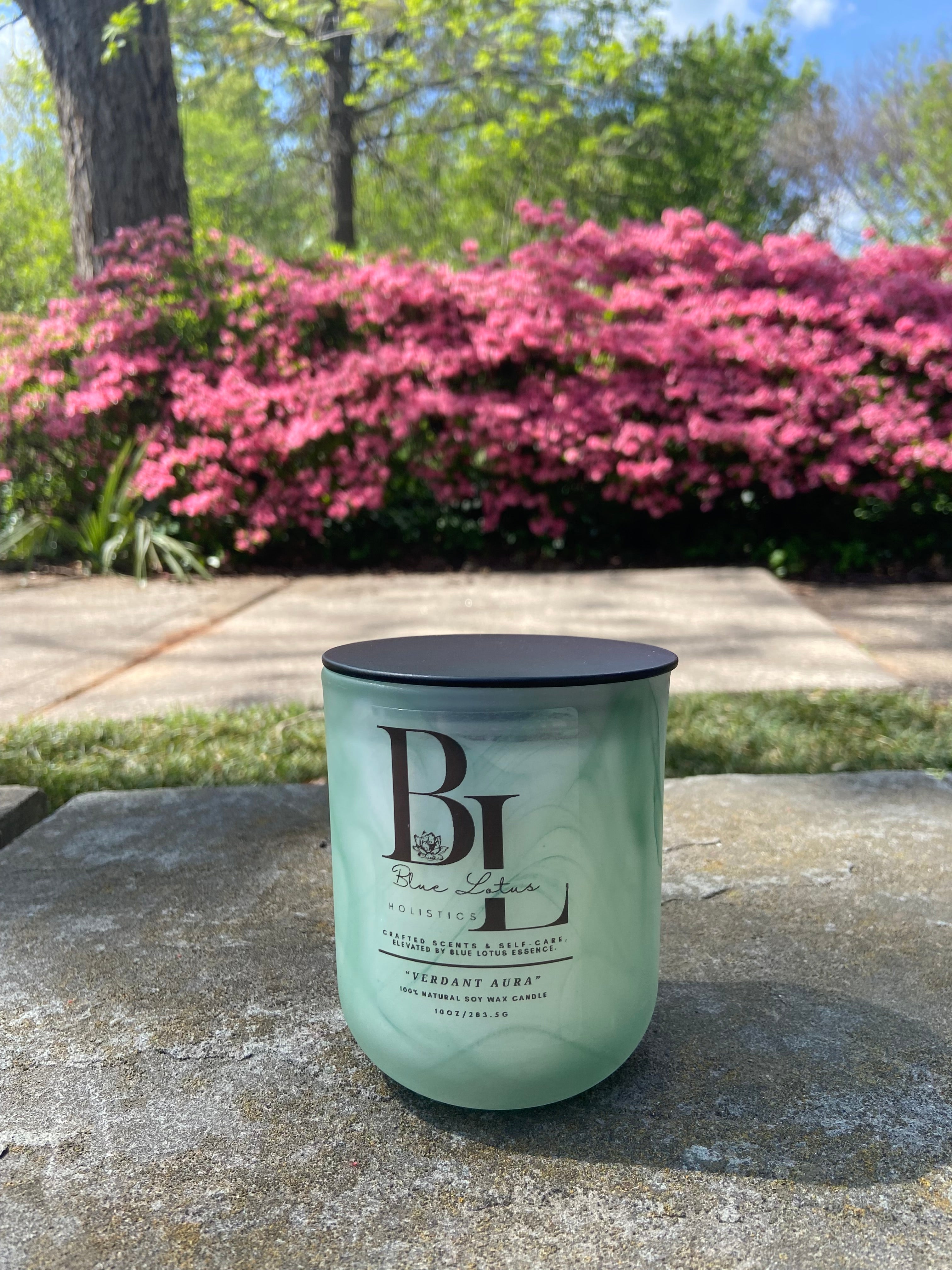 Verdant Aura natural soy candle displayed in an outdoor lifestyle setting